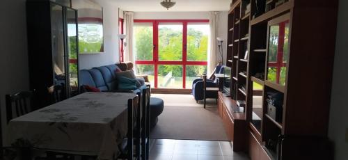 una sala de estar con una mesa y un sofá en Noja, Piso a 500 m de playa en urbanización tranquila y rodeada de naturaleza, en Noja