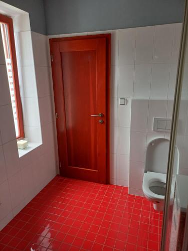 a bathroom with a toilet and a red door at Rodinný dům Polanka in Třebíč