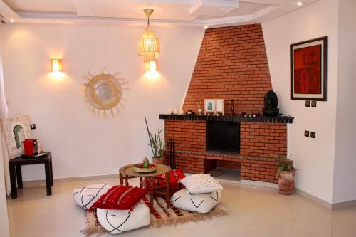 a living room with a brick fireplace and a table at Seaside 2 Bedrooms Villa - IMI OUADDAR in Agadir