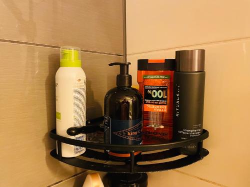 a shelf on a bathroom wall with bottles of soap at Modern Home in Peaceful Area with Private Lawn, BBQ & Free Parking in Kauniainen