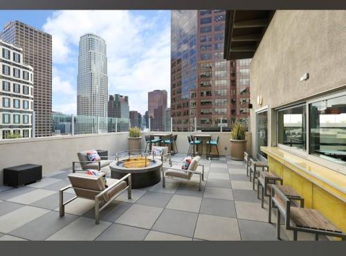 a rooftop patio with chairs and a fountain on a building at Cozy 2BR Apt in Downtown LA with Pool & Hot Tub in Los Angeles