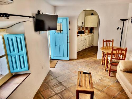 a living room with blue doors and a table at Tradicional casa con impresionantes vistas in Gaucín