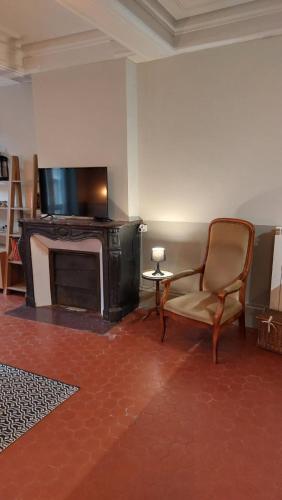 Il comprend un salon avec une chaise et une télévision à écran plat. dans l'établissement Appartement calme à 100m des Allées Paul Riquet, à Béziers