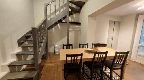 une salle à manger avec une table et un escalier dans l'établissement Appartement calme à 100m des Allées Paul Riquet, à Béziers