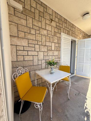 a table and chairs in front of a brick wall at Apartments Olga 2 in Makarska