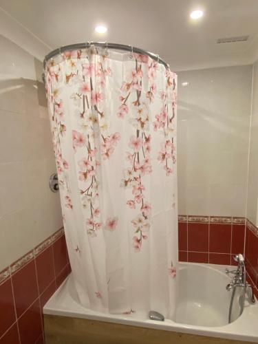 a shower curtain with pink flowers on a tub at 200A Ringwood Road in Poole