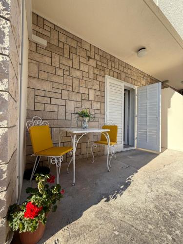 a patio with a table and chairs on a brick wall at Apartments Olga 2 in Makarska