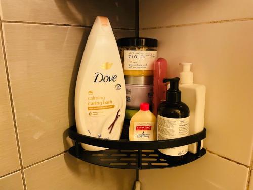 a shelf in a bathroom with some bottles of soap at Modern Home in Peaceful Area with Private Lawn, BBQ & Free Parking in Kauniainen