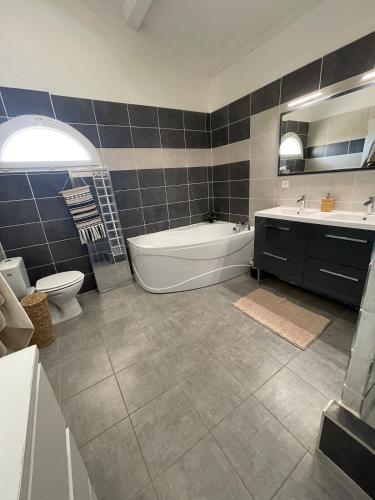 une salle de bain avec une baignoire, des toilettes et un lavabo dans l'établissement -Villa vigneronne moderne piscine et jaccuzi, à Saint-Jean-de-Fos