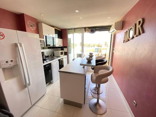 une cuisine avec un réfrigérateur blanc et un comptoir dans l'établissement Studio 2 couchages CAP D'AGDE NATURISME CN060-AB146, au Cap d'Agde
