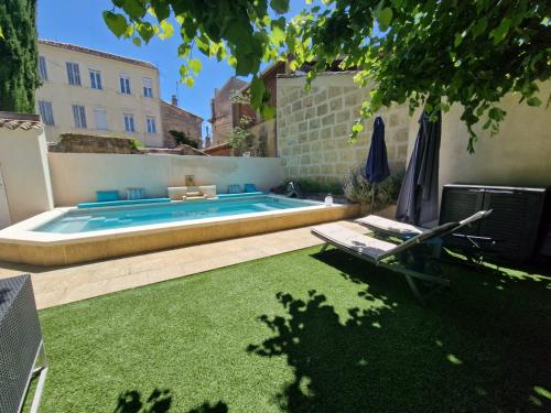 une cour avec une piscine et une pelouse dans l'établissement Magnifique maison de ville avec piscine au cœur de la Provence, à Salon-de-Provence