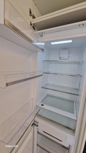 un réfrigérateur vide avec sa porte ouverte dans une cuisine dans l'établissement Apartamento en Montpellier, à Montpellier