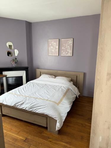 ein Schlafzimmer mit einem großen Bett mit weißer Bettwäsche in der Unterkunft Séjour à Paris in Aubervilliers