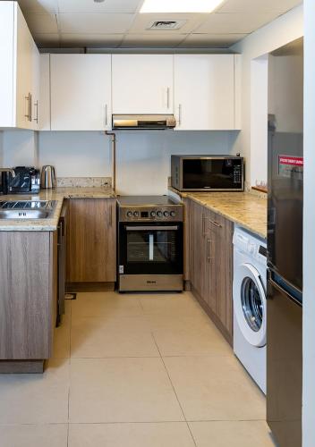 a kitchen with a stove and a dishwasher at 2BR Apartment In Dubai in JVC near Circle mall in Dubai
