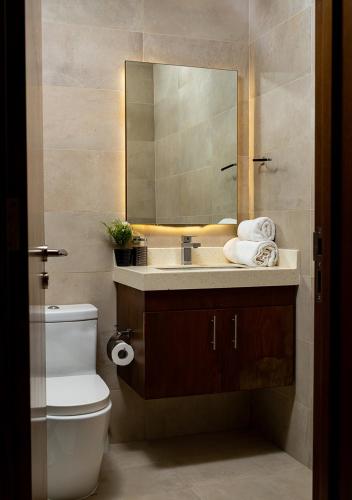a bathroom with a sink and a mirror and a toilet at 2BR Apartment In Dubai in JVC near Circle mall in Dubai