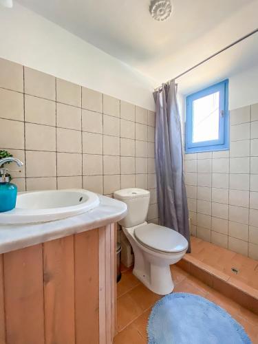 a bathroom with a toilet and a sink and a window at Kyparissis Beach house 1 in Lésvos