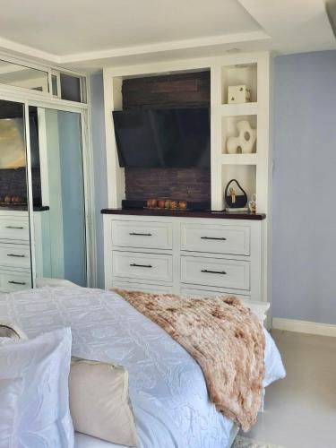 a bedroom with a bed with a flat screen tv at Bayfront Luxury beachfront escape with Pool in Portmore Book Now in Portmore
