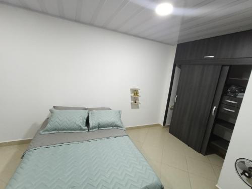 a bedroom with a large bed with blue pillows at Hospedaje samfer in Envigado
