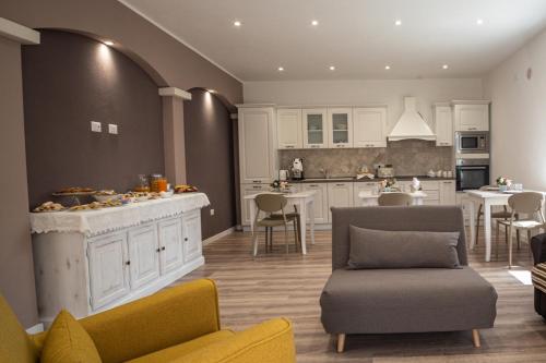 a kitchen and living room with a counter and chairs at Casa Midò in Muravera