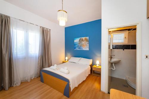 a bedroom with a bed and a blue wall at Apartmani Tinka in Starigrad