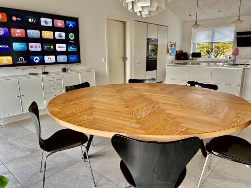 einen großen Holztisch in einer Küche mit Stühlen in der Unterkunft Spacious City Family Retreat With Garden & Patio in Odense