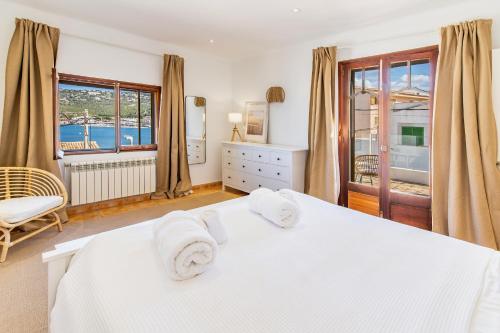 a bedroom with a white bed with towels on it at Ca Ne Margalide by Mallorca Infinity in Port d’Andratx