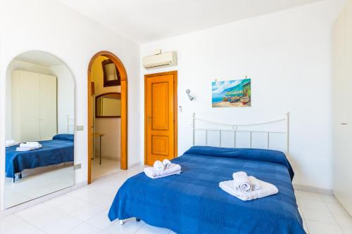 Un dormitorio con una cama azul con toallas. en Blue residence, en Amalfi