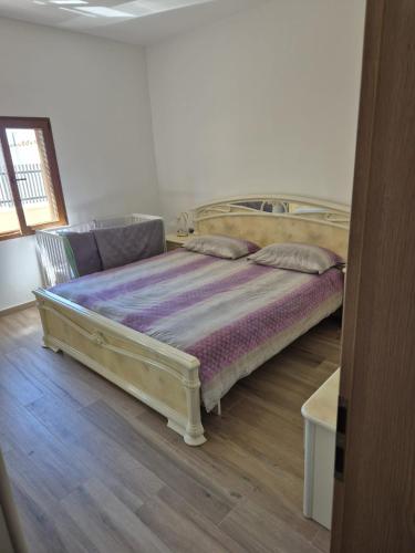 a large bed in a room with a wooden floor at Apartment Anastazija in Nin