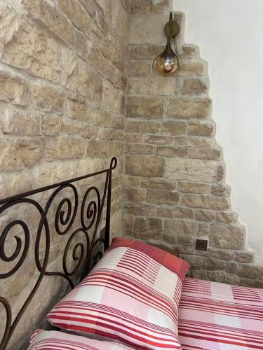 a bed in a room with a stone wall at Apartment Nikolina in Trogir