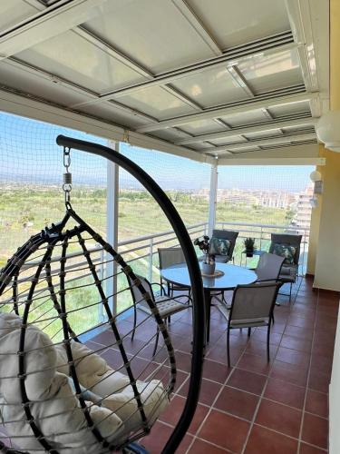 een veranda met een schommel en een tafel en stoelen bij Apartamento NEPTUNO PLAYA in Peñíscola