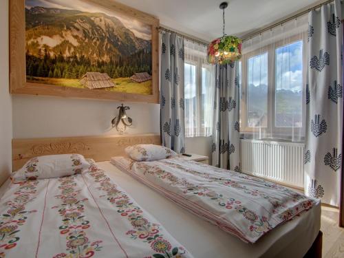 a bedroom with a bed and a painting on the wall at Pokoje Zamoyskiego - WATRA in Zakopane