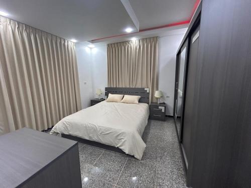 una camera da letto con un letto, due tavoli e tende di Raha's house a Jerash