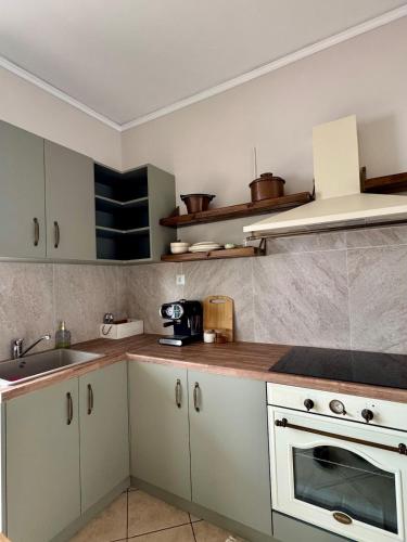 a kitchen with white cabinets and a white stove top oven at Olive House in Khalkoútsion