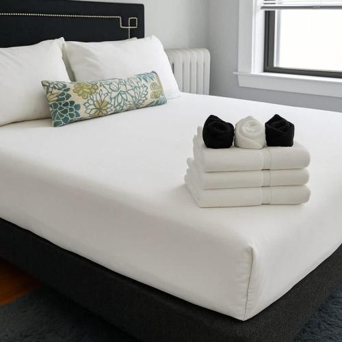 a white bed with two towels and two candles on it at 1BR Fully Equipped & Central - Belmont rep in Chicago