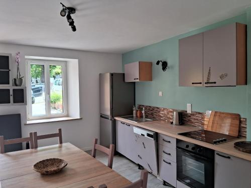 une cuisine avec une table et un réfrigérateur dans l'établissement Le 46 pour 2 personnes, à Crots