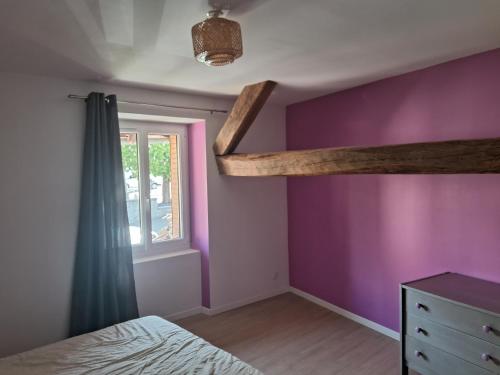 - une chambre avec un lit et un mur violet dans l'établissement Le 46 pour 2 personnes, à Crots