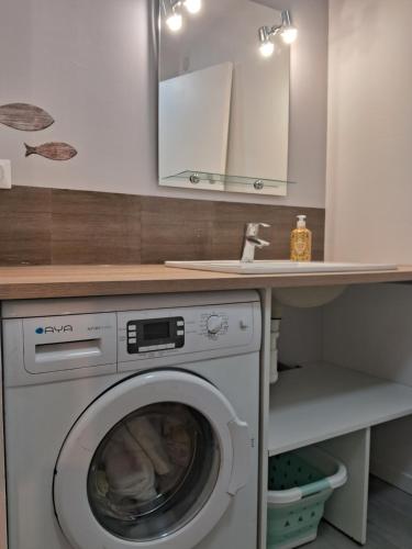 - une buanderie avec un lave-linge sous un comptoir dans l'établissement Le 46 pour 2 personnes, à Crots