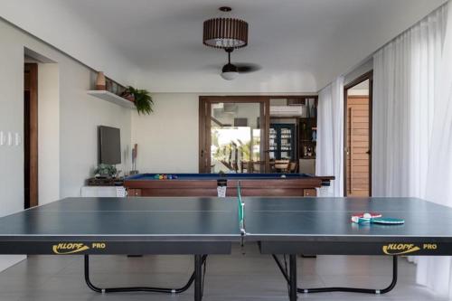 a ping pong table in the middle of a living room at casa de guarajuba in Camacari
