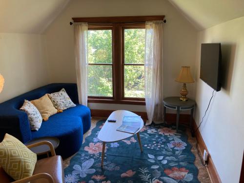 a living room with a blue couch and a window at Historic Glacier Getaway with Spectacular Views-20mins to Glacier National Park-10mins to airport and walkable to downtown! in Columbia Falls