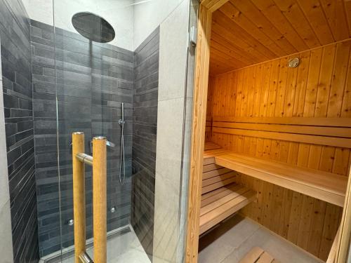 a sauna with a glass shower and wooden walls at Sauna y in Cluj-Napoca
