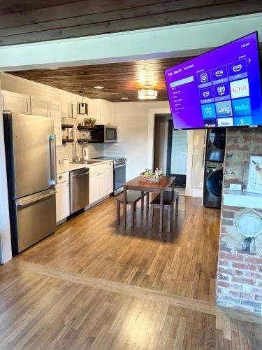 a large kitchen with a table and a large screen at Little Bit-A-Cozy, 2BR Retreat in Hickory