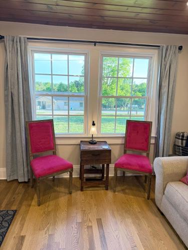 a living room with two chairs and a table and windows at Little Bit-A-Cozy, 2BR Retreat in Hickory