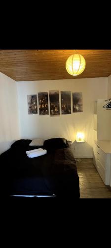 a bedroom with a black bed and a light at Appartement avec vue montagne in Briançon