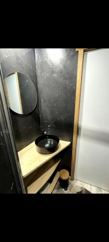 a small bathroom with a mirror and a sink at Appartement avec vue montagne in Briançon