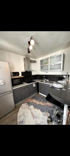 a kitchen with a table and a refrigerator at Appartement avec vue montagne in Briançon