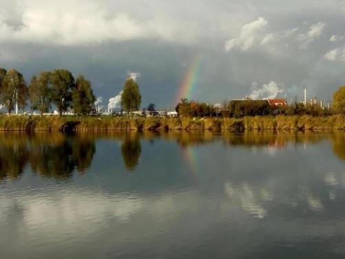 a rainbow over a body of water with a rainbow at Bungalow in Zuytland by Water and Nature in Simonshaven