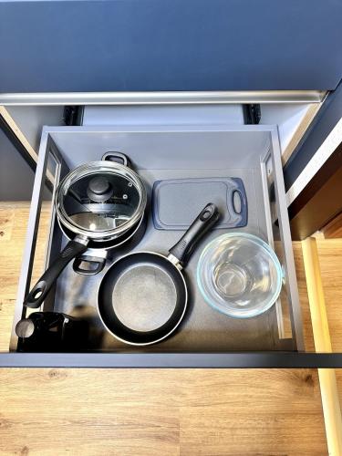 a tray with pots and pans in a drawer at City Apartment Bad Aussee in Bad Aussee