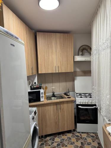 a kitchen with wooden cabinets and a white refrigerator at Damian House in Drobeta-Turnu Severin
