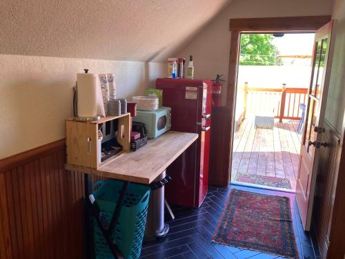 a kitchen with a refrigerator and a table with a microwave at Historic Glacier Getaway with Spectacular Views-20mins to Glacier National Park-10mins to airport and walkable to downtown! in Columbia Falls