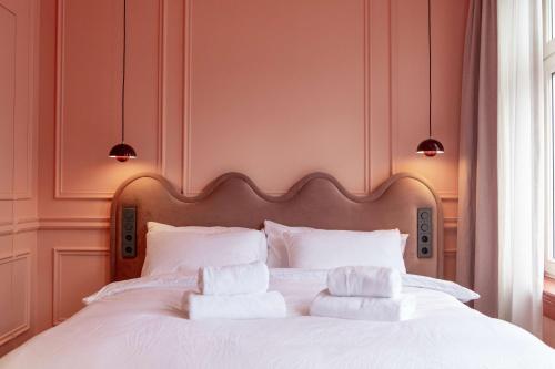 a bedroom with a white bed with three pillows at Suite Palette in Amsterdam